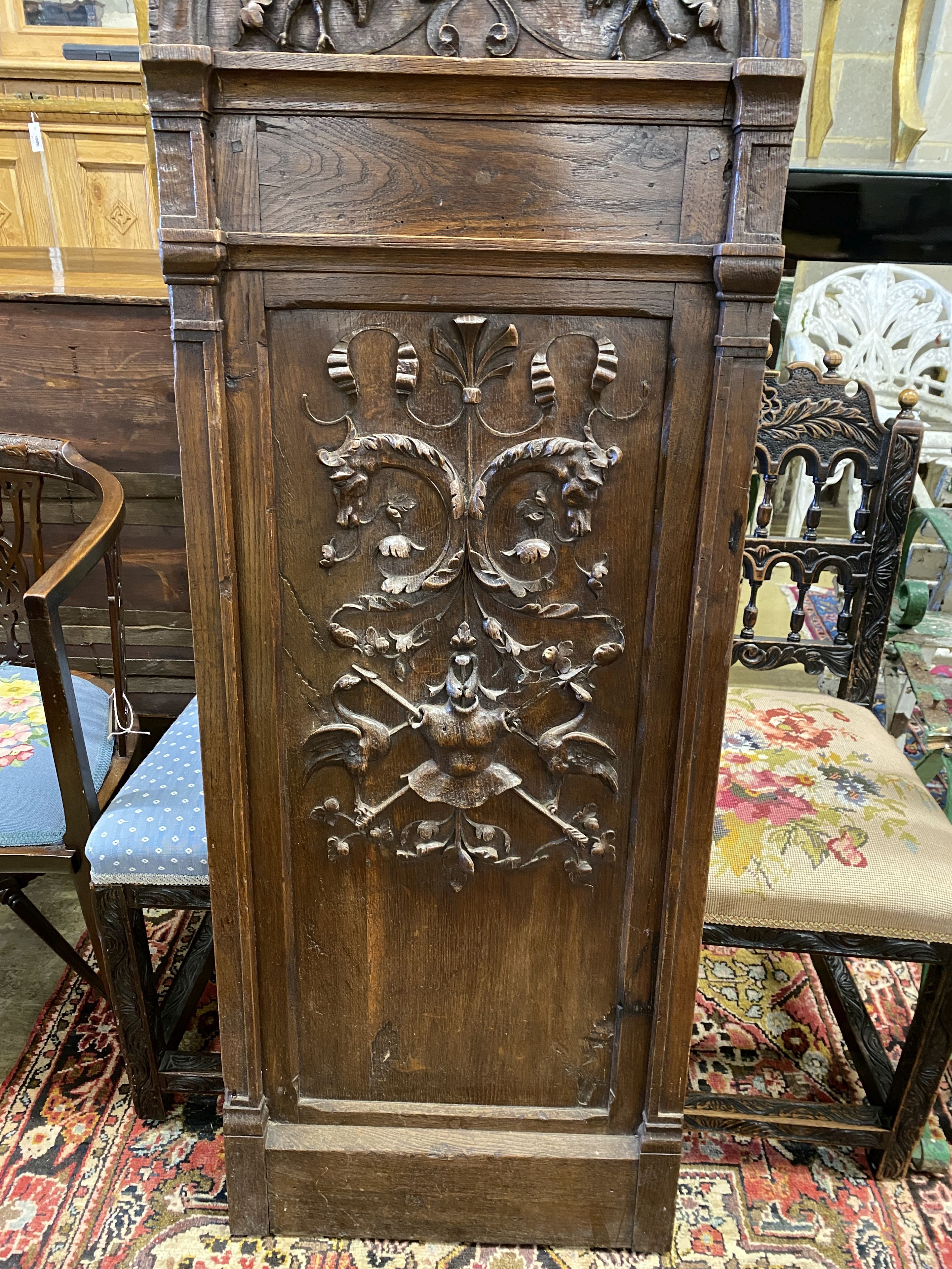 A 19th century carved oak plaque with cherub head pediment, width 50cm, height 145cm